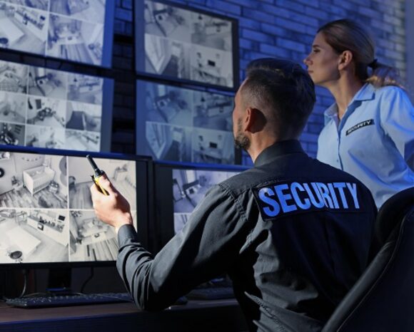 Security guards monitoring modern CCTV cameras indoors