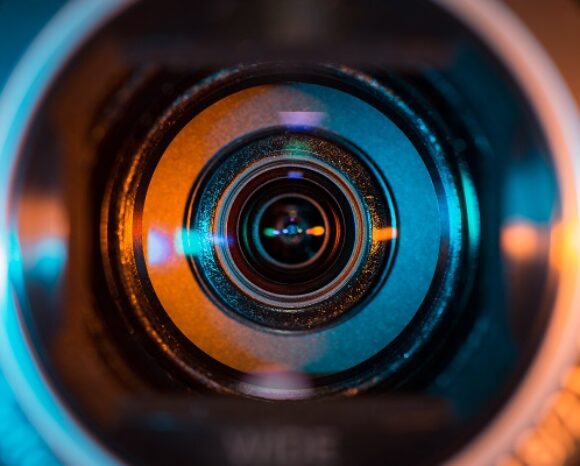 Video camera lens lit by blue and orange color light