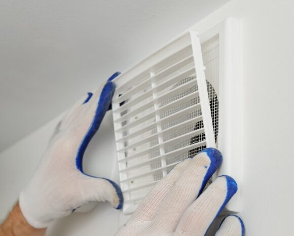 Worker installs ventilation grille.