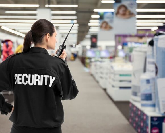 Security guard using portable radio transmitter in shopping mall, space for text
