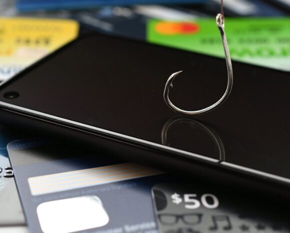 Phishing phone call scams vishing - concept. Cellphone with fishing hook, credit cards & gift cards