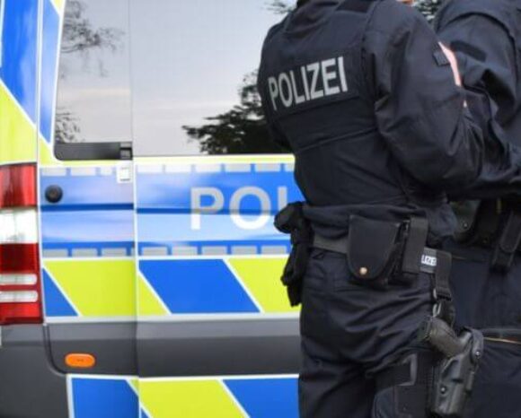 Polizeibeamte stehen vor einem Polizeiwagen