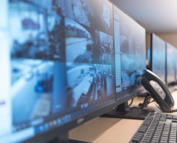 Wachmann überwacht moderne CCTV-Kameras im Überwachungsraum.