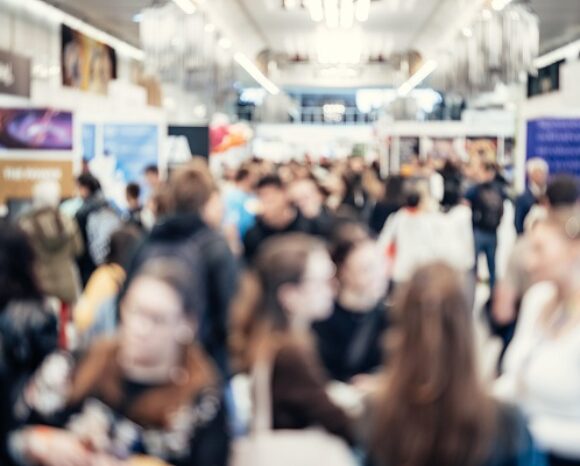 Abstrakt verschwommene Menschen in einer Ausstellungshalle.