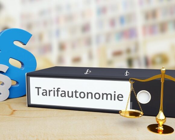 Tarifautonomie – Recht/Gesetz. Ordner auf Schreibtisch mit Beschriftung neben Paragraf und Waage.
