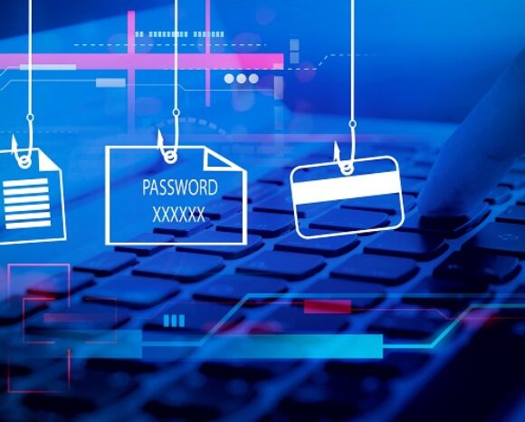 Ein Finger tippt auf einer Tastatur. Darüber befinden sich drei Symbole an Angelhaken: ein Dokument, eine Datei mit der Bezeichnung „Passwort XXXXXX“ und eine Kreditkarte. Der Hintergrund ist digital blau und erinnert an Phishing und Datenschutzbedrohungen.