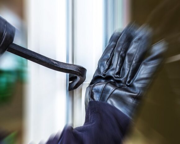 Ein unbekannter Einbrecher hebelt eine Terrassentür auf