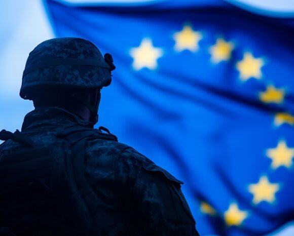 Soldat steht vor einer EU-Flagge