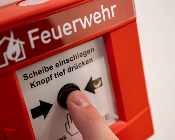Brandmelder mit Finger auf dem Auslöser