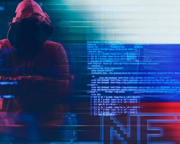 Mann in rotem Hoodie steht neben einer digitalen russischen Flagge, Hacker