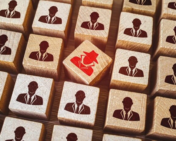 Bausteine mit Personen drauf, einer davon in rot, der Spion