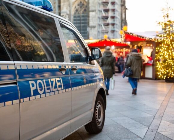 Einsatzwagen der Polizei parkt vor einem weihnachtsmarkt