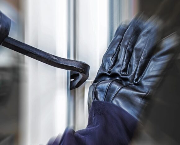 Ein unbekannter Einbrecher hebelt eine Terrassentür auf.