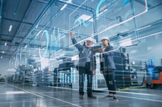 Zwei Wirtschaftsingenieure visualisieren mithilfe eines Tablet-Computers die Wand aus Big-Data-Statistiken.