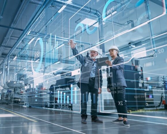 Zwei Wirtschaftsingenieure visualisieren mithilfe eines Tablet-Computers die Wand aus Big-Data-Statistiken.