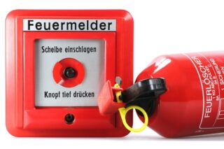 Feuermelder und Feuerlöscher isoliert auf weißem Hintergrund