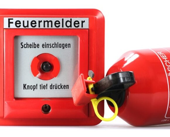 Feuermelder und Feuerlöscher isoliert auf weißem Hintergrund
