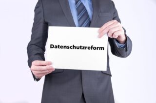 Mann hält ein Schild mit dem Wort Datenschutzreform