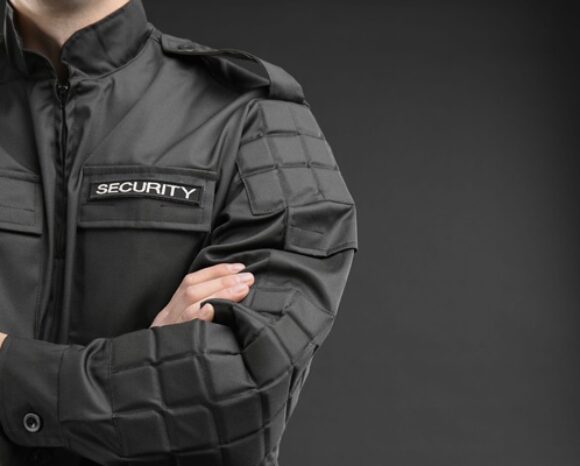 Männlicher Sicherheitsbeamter in Uniform vor dunklem Hintergrund