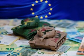 2 Miniatur Panzer auf Euro-Scheinen mit EU-Flagge im Hintergrund