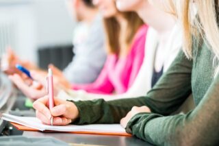 Person schreibt auf Block Papier